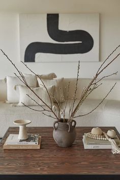 a living room with a couch, coffee table and vase