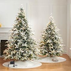 two artificial christmas trees are sitting on the floor