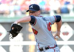 a baseball player pitching a ball on top of a field