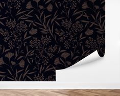 a black and brown floral wallpaper design with leaves on it's back side