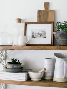 a shelf with various items on top of it and a framed photo in the background