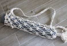 a white crocheted bag sitting on the floor in front of a tile floor