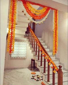an orange and white staircase decorated with balloons, streamers and garlands on the stairs