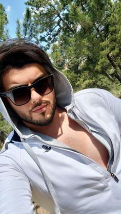 a man wearing sunglasses and a hoodie taking a selfie with his cell phone