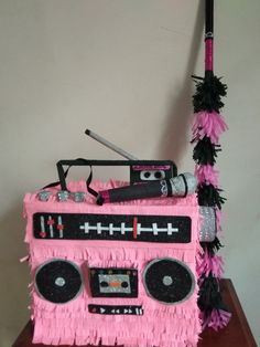 a cake made to look like a pink boombox with black fringes on it