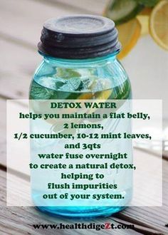 a jar filled with water sitting on top of a wooden table next to lemons