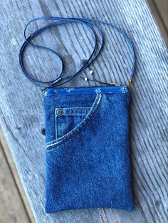 a small blue purse sitting on top of a wooden table next to a cell phone