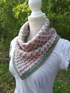 a white mannequin wearing a pink and green knitted cowl on it's neck