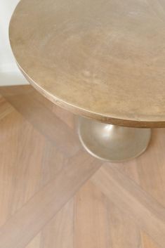 a round wooden table sitting on top of a hard wood floor