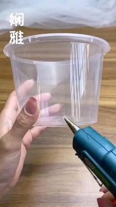 two hands holding a plastic container with a screwdriver in it and another hand holding a pen