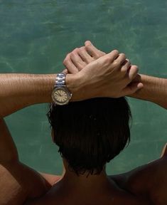 a man holding his hands over his head in the water