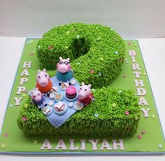 the birthday cake is decorated with green grass and animals
