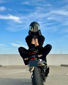 a person sitting on the back of a motorcycle with their feet up in the air