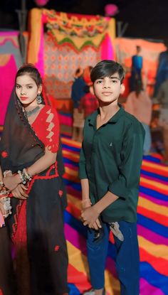 two young children standing in front of colorful carpet