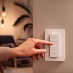 a person pressing the button on a light switch