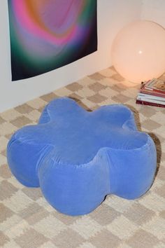 a blue bean bag chair sitting on top of a carpet