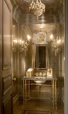 a fancy bathroom with gold fixtures and chandelier