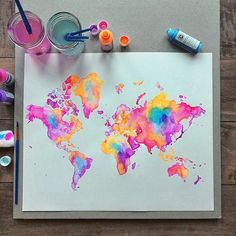 the world map is painted with watercolors and crayons on a piece of paper