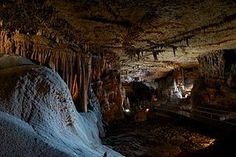 the inside of a cave with icicles hanging from it's ceiling and lights on