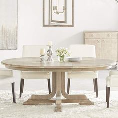 a dining room table with white chairs around it