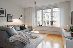 a living room filled with furniture and a flat screen tv sitting on top of a hard wood floor