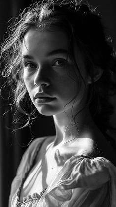 a black and white photo of a woman in a dress looking off to the side