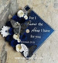 a blue graduation cap with white flowers and butterflies on it that says for i know the plans i have for you