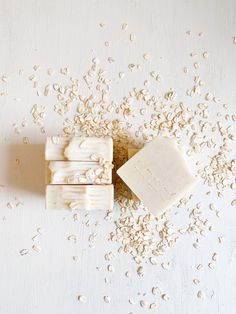 oatmeal and soap bar sitting on top of a white surface with seeds scattered around it