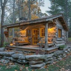 a small log cabin in the woods with stone steps leading up to it's front door