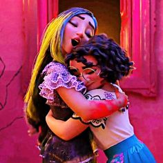 two girls hugging each other in front of a pink wall