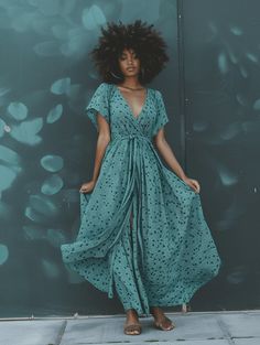 This teal maxi dress adorned with subtle polka dots offers a dreamlike quality that’s perfect for both daytime and evening occasions. The wrap style cinches at the waist, creating a flattering shape that suits all body types. It’s an outfit made for the fashion-forward woman who finds beauty in the details and enjoys standing out with understated elegance. Paired with tan sandals, it’s the embodiment of spring’s casual yet chic vibe. Teal Maxi Dress, Tan Sandals