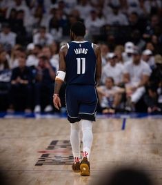 a basketball player is walking on the court with his foot in front of him and people watching