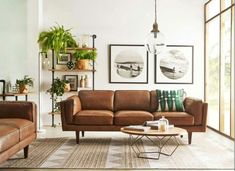 a living room with two couches, a coffee table and pictures on the wall