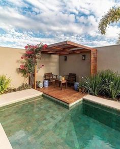 an image of a house with a pool in the middle and some plants around it