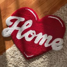 a heart shaped rug with the word home written on it