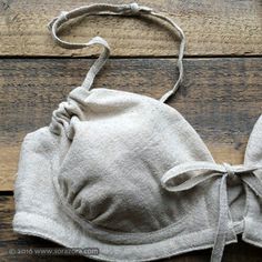 a bra made out of linen on top of a wooden floor with a knot at the bottom