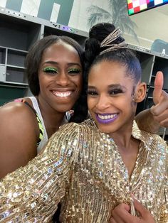 two women in gold sequins posing for the camera with one giving thumbs up