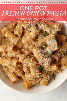 one pot french onion pasta with parmesan cheese and herbs in a white bowl