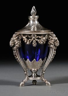 an ornate silver and blue glass urn