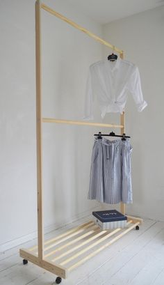 a white shirt hanging on a clothes rack next to a blue and white striped skirt