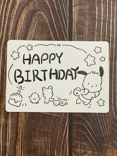 a happy birthday sticker on a wooden surface