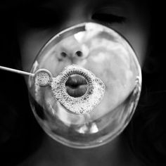 a woman's face is reflected in a glass bowl with a red lip on it