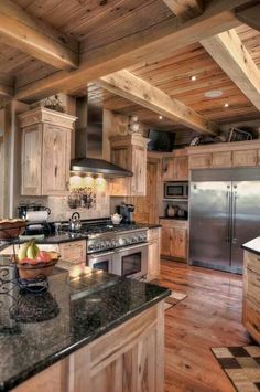 a kitchen with wooden walls and flooring has granite counter tops, an island in the center