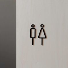 two black stickers on the side of a white door with a woman and man symbol