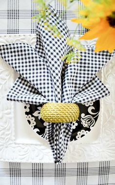 a black and white checkered table cloth with a yellow flower in the center on it