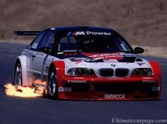 a bmw race car with flames coming out of it's tires