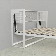 a white bed frame with wooden slats on the top and bottom sides, in front of a gray wall