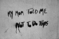 graffiti written on the side of a building says, my mom told me not to do this