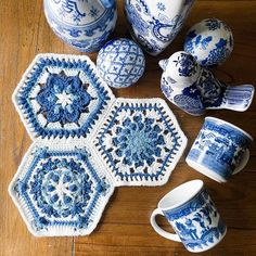 blue and white crocheted coasters, cups, and vases on a wooden table