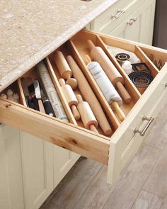 an open drawer in the middle of a kitchen